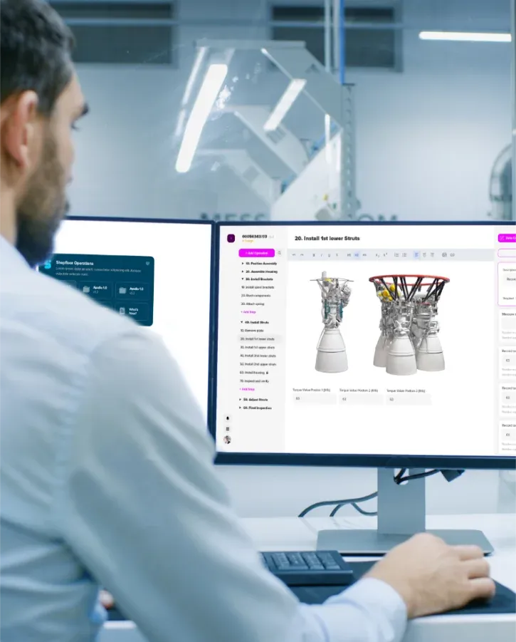 Man at a desk looks at two computer monitors displaying MES software. The left screen shows 'Shopfloor Operations' with Apollo project tabs. The right screen shows assembly instructions with 3D models of rocket engines.