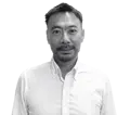 Headshot of Kenzo Takai, Manufacturo's Chief Operations Officer, a middle-aged East Asian man with short dark hair, a goatee, and a slight smile, wearing a white collared shirt against a white background.
