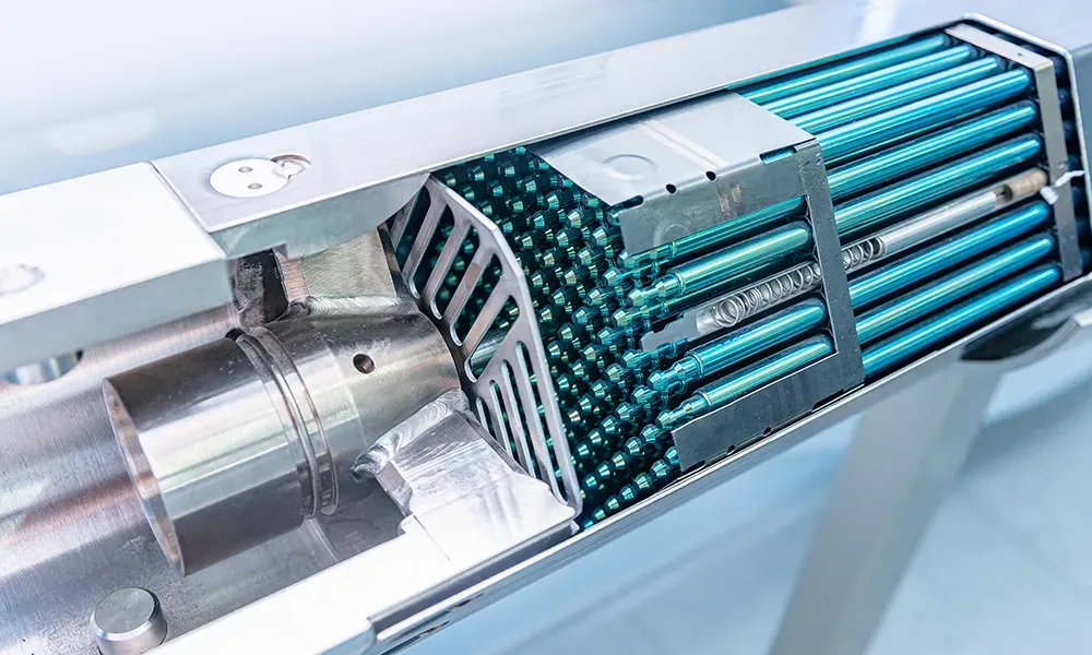 Cutaway view of an SMR fuel assembly showing numerous bright blue fuel rods arranged in a grid within a metallic housing, indicating advanced nuclear reactor technology.