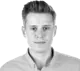 Black and white studio portrait of Michal Niemiec, Senior Product Manager, looking at the camera in a collared shirt.