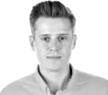 Black and white studio portrait of Michal Niemiec, Senior Product Manager, looking at the camera in a collared shirt.