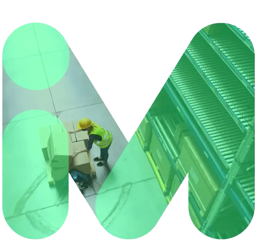A warehouse worker in a yellow hard hat and vest is arranging boxes inside a large green M-shaped graphic. Shelving units are visible in the background.